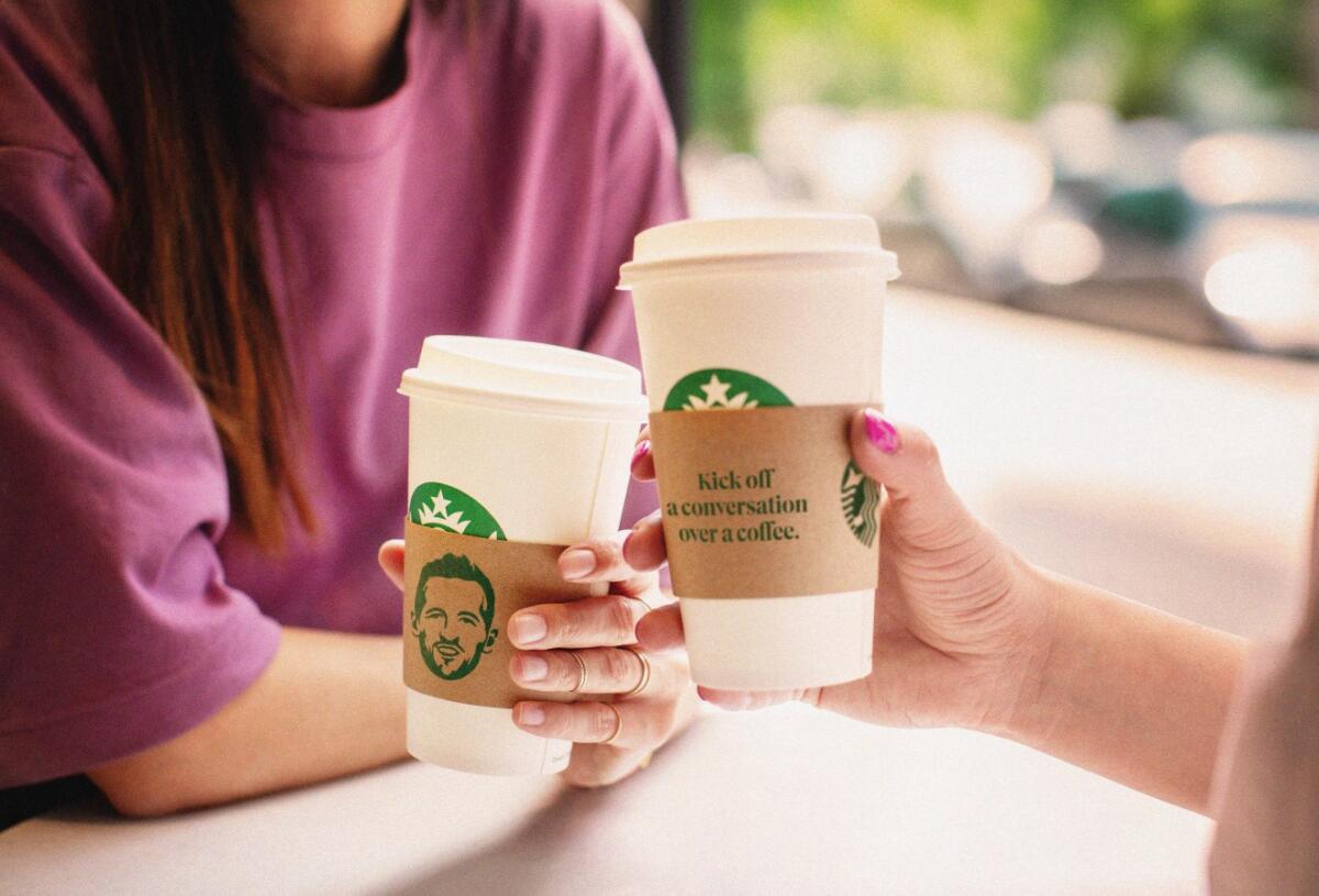 Two Starbucks coffee cups with Harry Kane's face on 