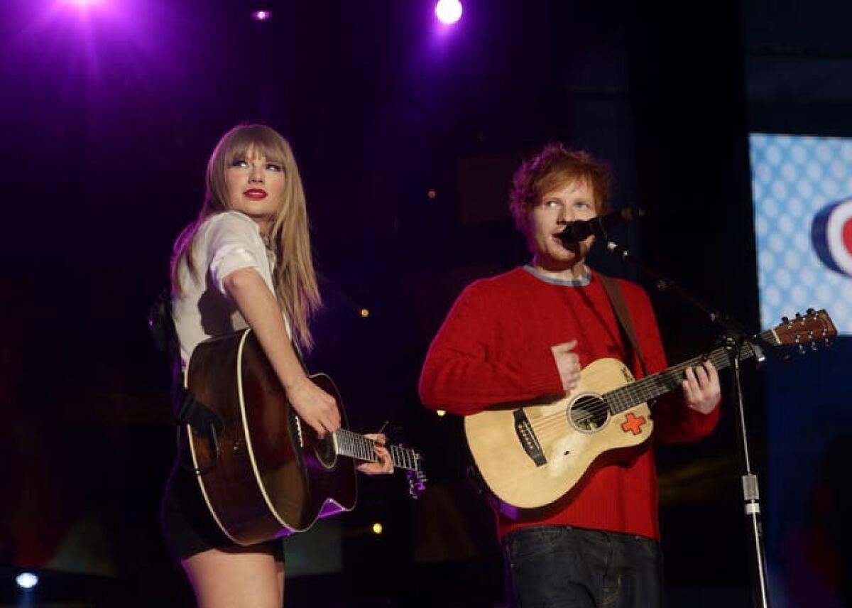 Taylor Swift and Ed Sheeran on stage holding guitars