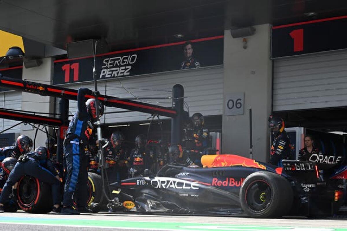Red Bull's Max Verstappen arrives in the pits with a damaged tyre