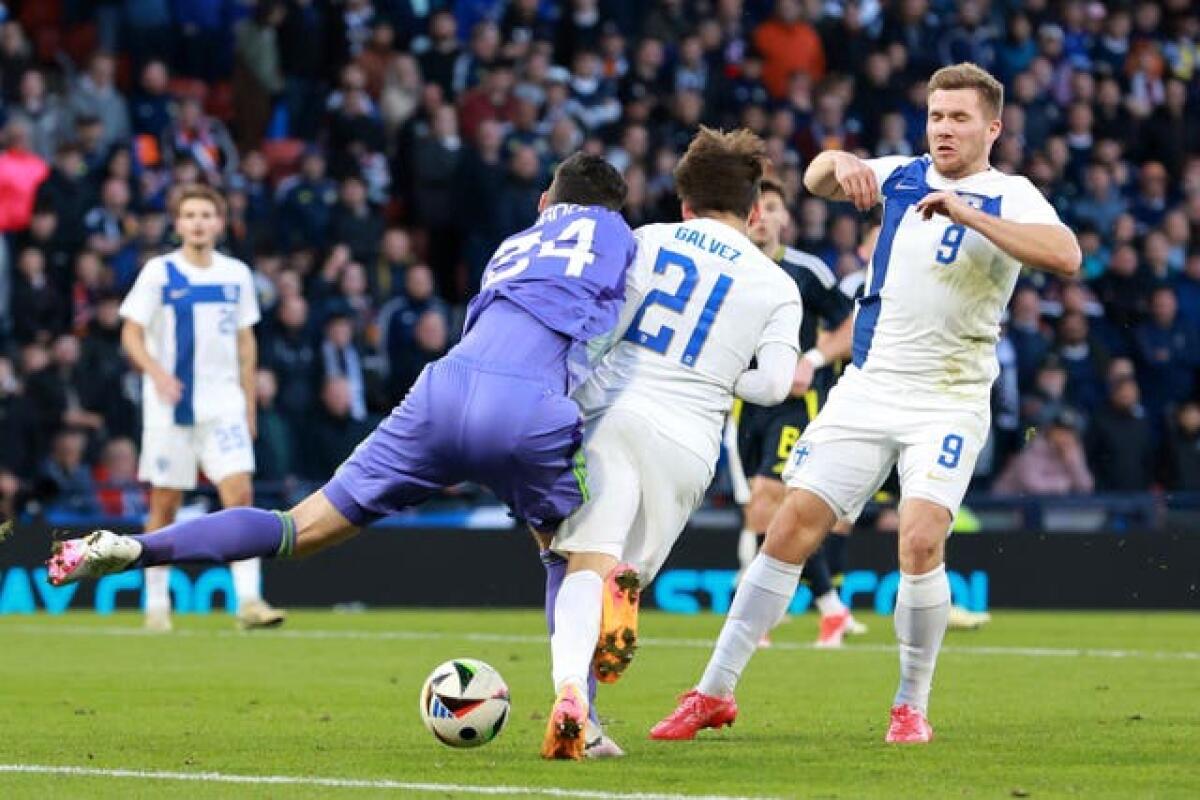 Scotland goalkeeper Craig Gordon, left, collides with Finland’s Finland's Tomas Galvez to concede a penalty