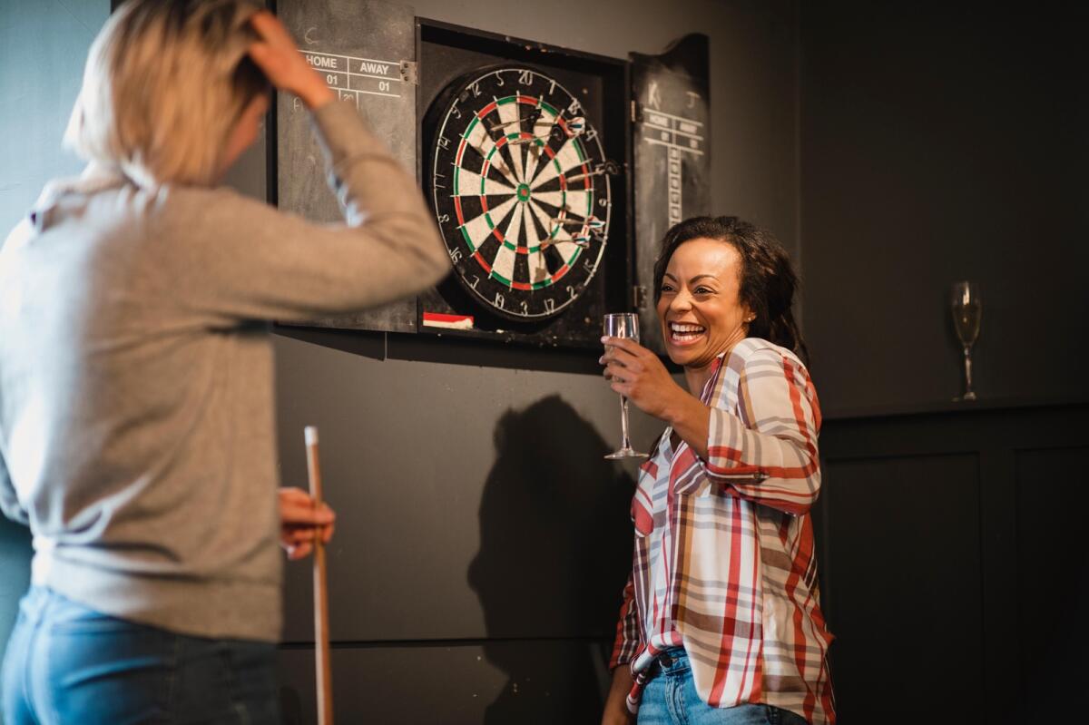 Friends playing darts in the pub