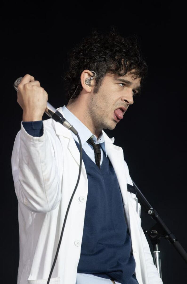 Matty Healy performing in a white coat