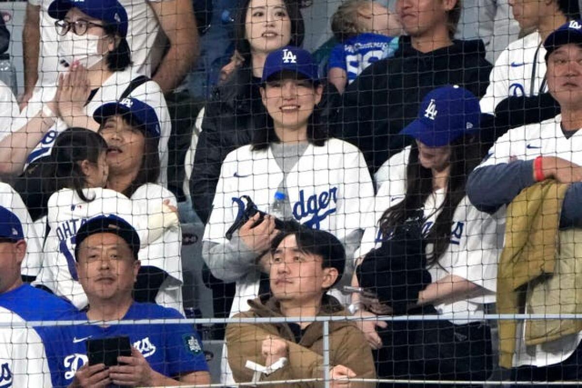 Mamiko Tanaka, centre, wife of Los Angeles Dodgers’ Shohei Ohtani watches during an opening day baseball game between the San Diego Padres and the Dodgers at the Gocheok Sky Dome in Seoul, South Korea 