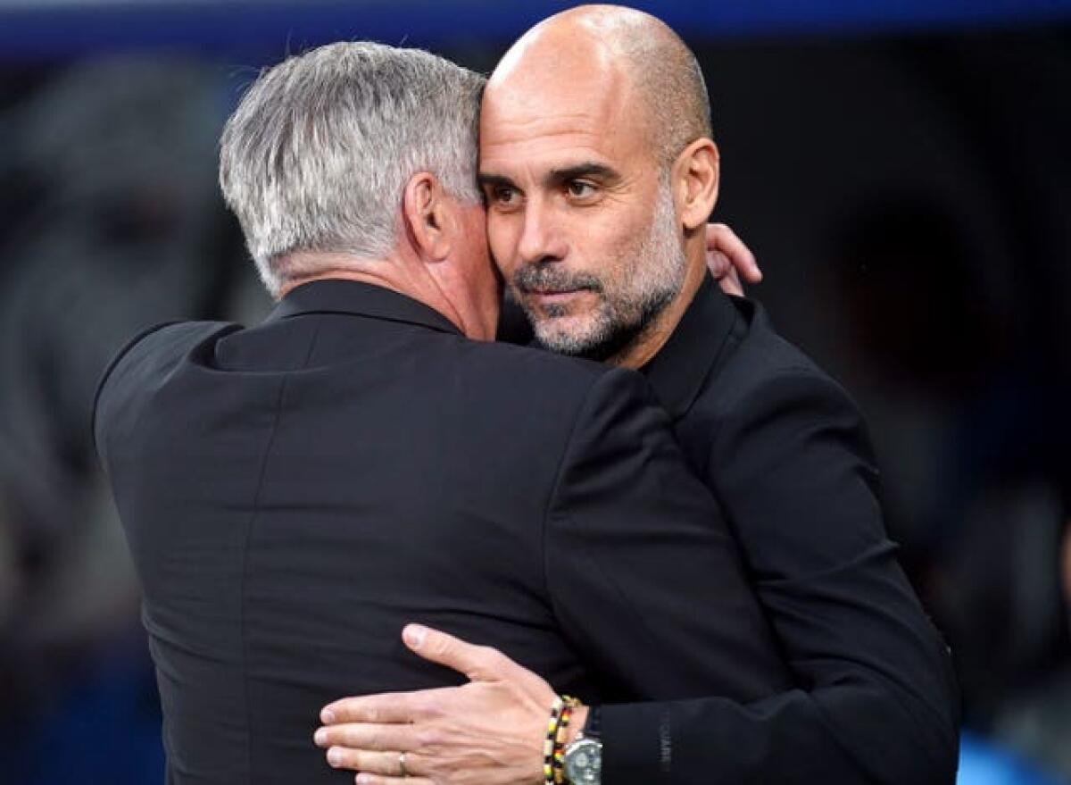 Manchester City boss Pep Guardiola, right, and Real Madrid manager Carlo Ancelotti embrace