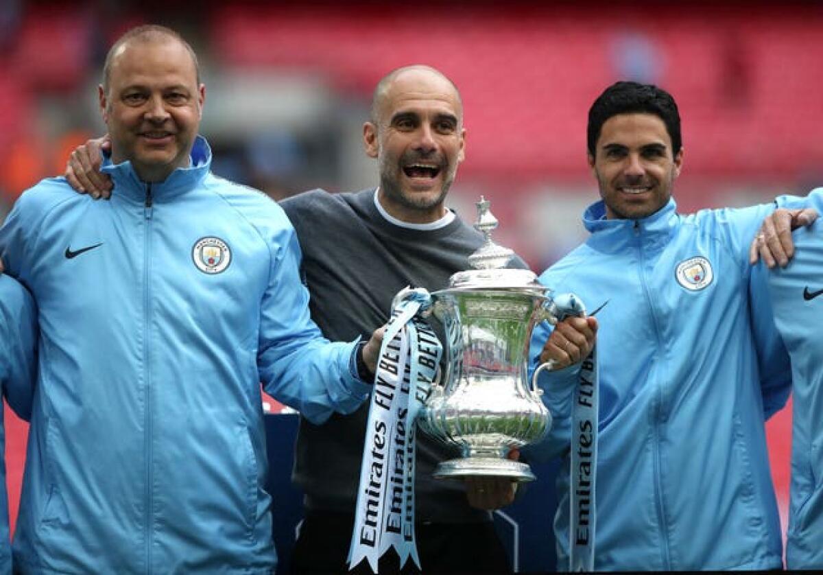 Pep Guardiola celebrates winning the FA Cup in 2019 with some of his backroom team