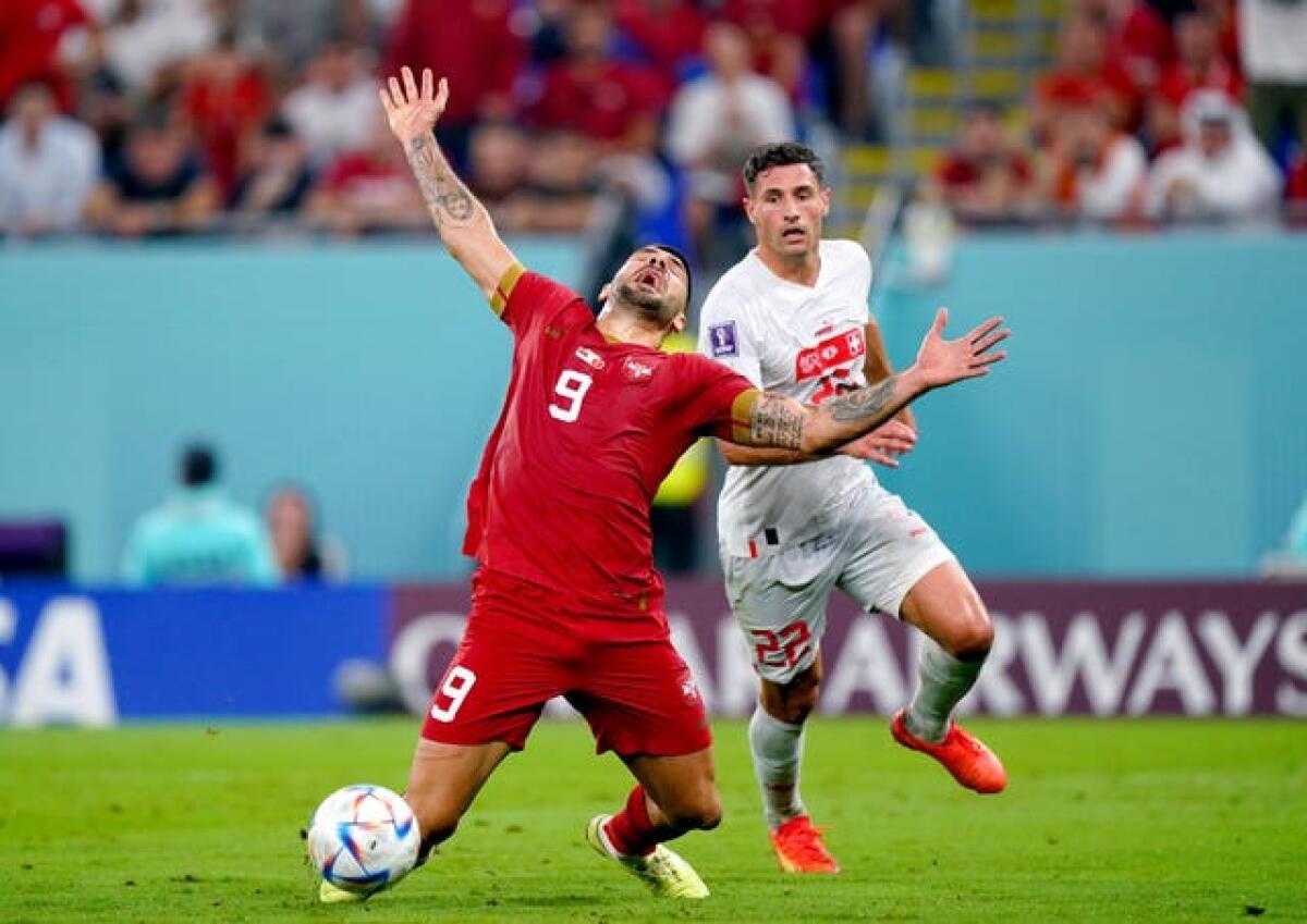 Serbia’s Aleksandar Mitrovic ) goes down whilst battling for the ball with Switzerland’s Fabian Schaer 