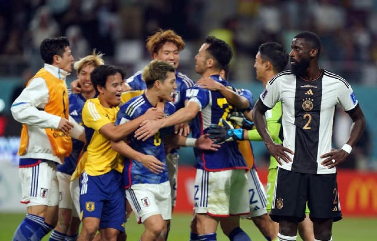 Japan players celebrate victory over Germany at the World Cup