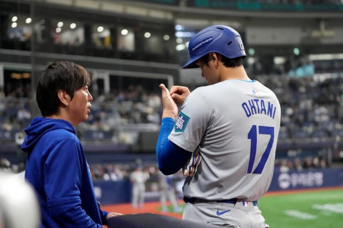 Los Angeles Dodgers designated hitter Shohei Ohtani, right, talks to his interpreter Ippei Mizuhara during the fifth inning of an opening day baseball game against the San Diego Padres at the Gocheok Sky Dome in Seoul, South Korea on March 20