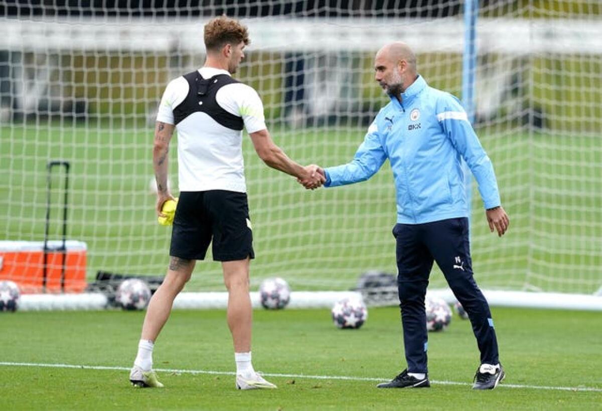 Manchester City manager Pep Guardiola (right) shake hands John Stones