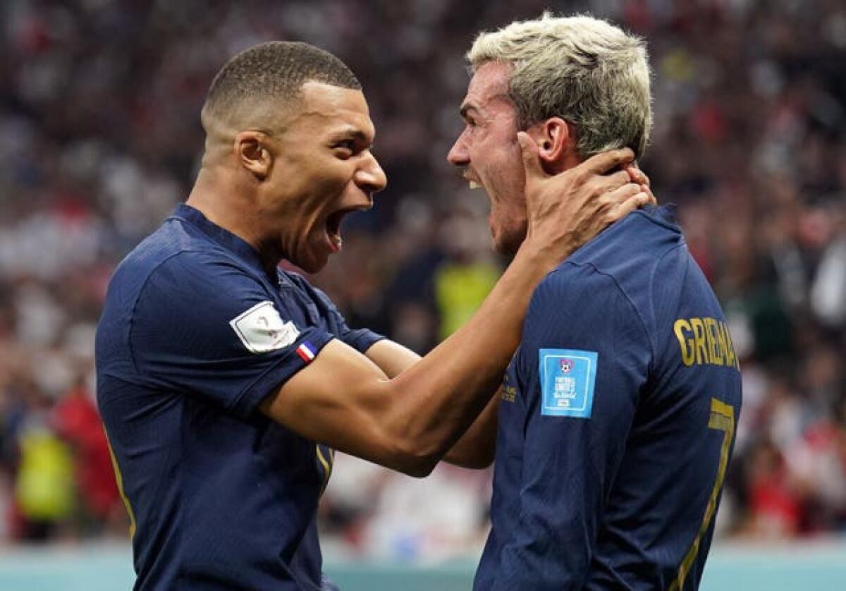 France’s Kylian Mbappe and Antoine Griezmann celebrate their sides second goal scored by Olivier Giroud during the FIFA World Cup Quarter-Final match at the Al Bayt Stadium in Al Khor, Qatar