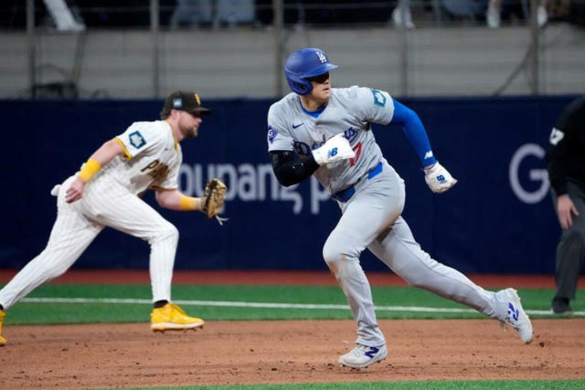 Los Angeles Dodgers designated hitter Shohei Ohtani, right, heads to second on a ball hit by Freddie Freeman during the eighth inning of an opening day baseball game against the San Diego Padres at the Gocheok Sky Dome in Seoul, South Korea on March 20
